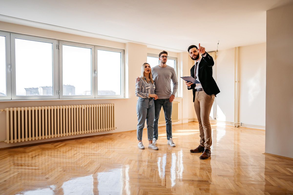 A real estate leasing agent shows a property to a couple